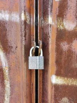 Old lock hanging on closed rusty gate. Private property and property Stock Photos
