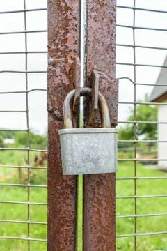 Old lock hanging on rusty gate Stock Photos