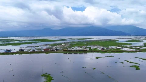 Old locomotive train running by Rawa Pening lake, Indonesia. Scenic aerial Stock Footage 303810115