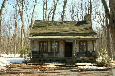 Old log cottage among maple trees Stock-Fotos