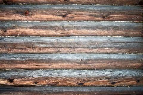 An old log wall of a rustic building with a texture. Wooden background. Stock Photos