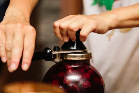 Old machine for rolling metal caps during storage. Preservation of compote fr Stock Photos
