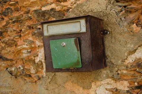 Old mailbox fixed to a wall of a dilapidated house Stock Photos