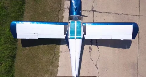 An old maize plane stands in a field, the camera slowly zooms out Video stock 138035104