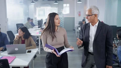 Old male boss looking through project documents made by female employee  Stock Footage 303399820