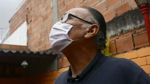Old man (+70) with a disposable face mask and glasses and a blue sweater outdoor Stock Footage 134294620