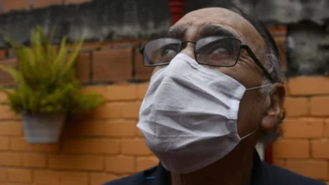 Old man (+70) with a disposable face mask and glasses and a blue sweater outdoor Stock Footage 134298586