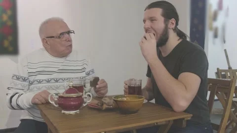 Old man and guy with beards spend time drinking tea in cafe Stock Footage 146324907