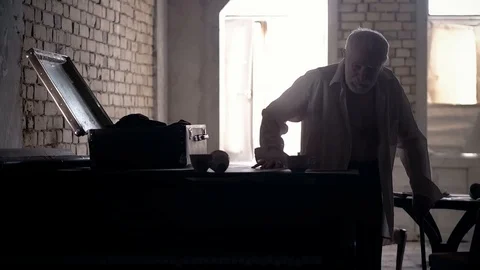 An old man of aristocratic appearance, but a bit disheveled, collects an old Stock Footage 100372952