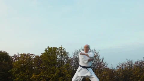 An old man athlete does formal karate exercises Stock Footage 143206649