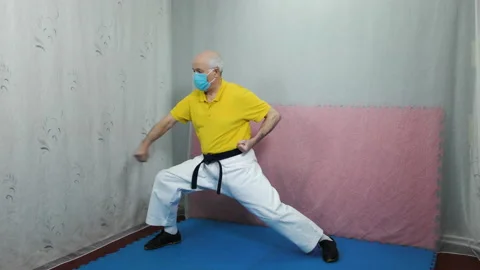 An old man athlete performs blocks with his hands in a rack Stock Footage 151283028