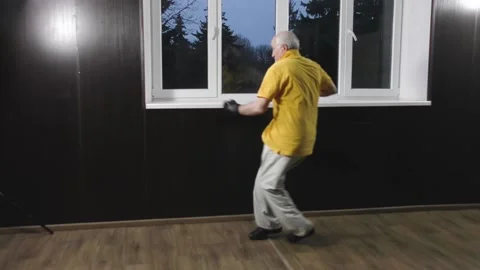Old man athlete performs a hand punch with a half-jump Stock Footage 151894328