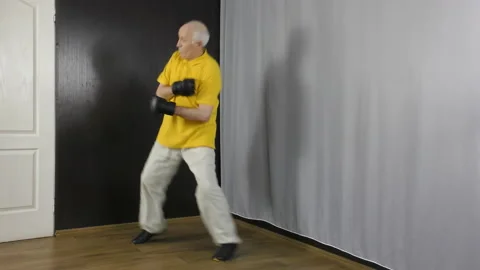 Old man athlete performs movement in racks and punches and kicks Stock Footage 151323941