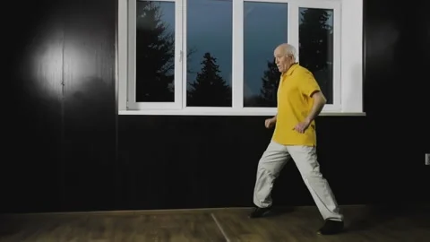 Old man athlete performs movement in a rack by the window Stock Footage 151324333