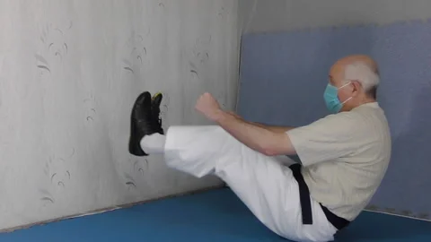 An old man athlete sitting  bends and stretches his legs Stock Footage 150313716