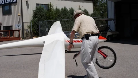 Old man is attaching the wheel to the wing of ultra light aircraft Stock-Footage 116121594