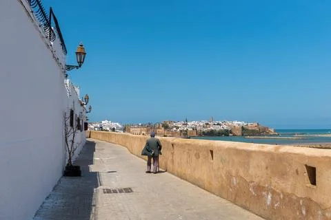 Old man back view walking at the embankment of Rabat town in Morocco Фото