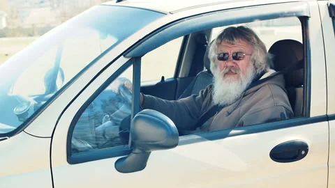 Old man with beard driving a car Stock Footage 89450611