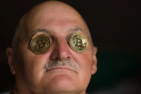 Old man with bitcoin coins in eyes Stock Photos
