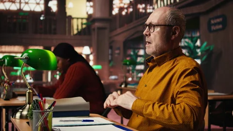 Old man in the campus library struggles with breathing and feeling unwell 스톡 동영상 313309183