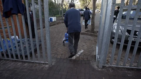 An old man carries twenty-five liters of water during drought in Cape Town Stock Footage 99342121