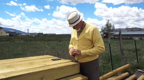 Old man checking lumber for DIY retirement project Stock Footage 62964124