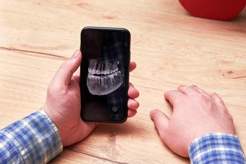 Old man checking an x-ray image of his jaw with a tooth implant Stock Photos