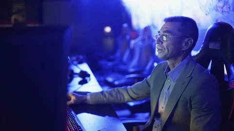 Old man in costume working on computer in Modern computer club. Stock Footage 136392324