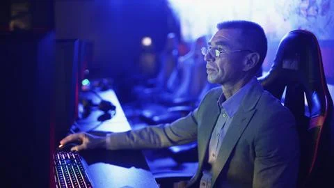 Old man in costume working on computer in Modern computer club. Foto stock