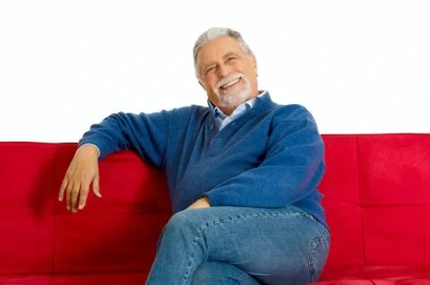 Old man on the couch smiling Stock Photos