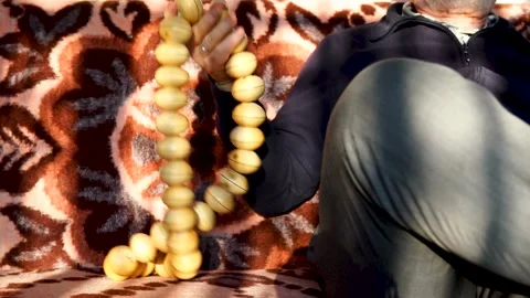An old man count a big, giant bead Stock Footage 132664710