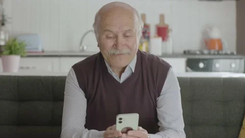 The old man dials the number on the smartphone. Stock Footage 188823679