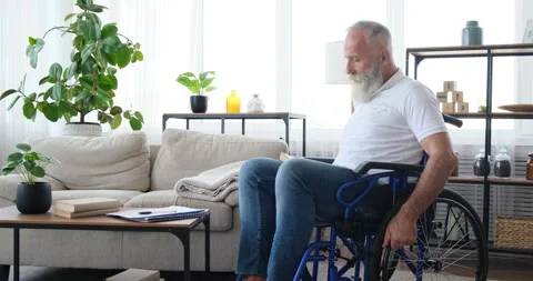 Old man with disability reading a book sitting on wheelchair Video stock 141657457