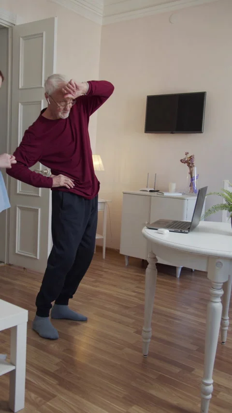 The old man does body tilts during training. The instructor is watching him Stock Footage 173567870