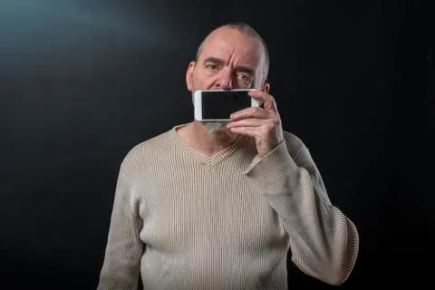 Old man does not understand his smartphone Stock Photos