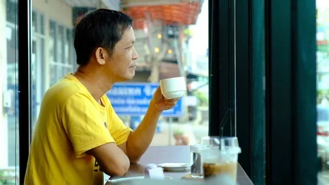 An old man drinking coffee in a coffee shop Stock Footage 120074024