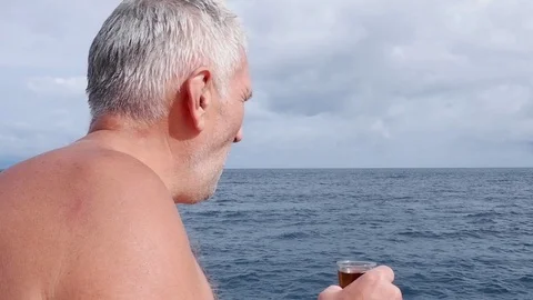 Old man drinks on the ocean. Video stock 122246222