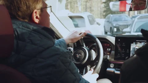 An old man drives a car, the interior of the car is in motion 库存影片 330767067