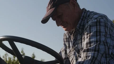 An old man drives a small tractor-trailer. Stock Footage 262254721