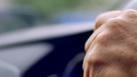 Old man driving car in day time, hand on steering wheel Stock Footage 80904062