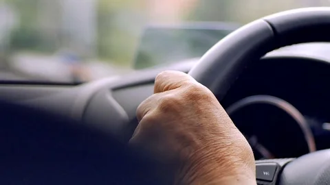 Old man driving car in day time, hand on steering wheel Stock Footage 80904141