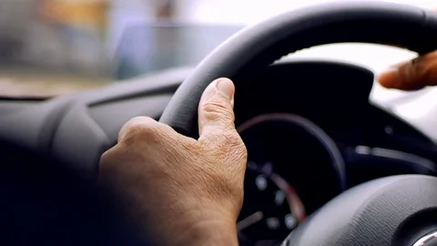 Old man driving car in day time, hand on steering wheel Stock Footage 80904207