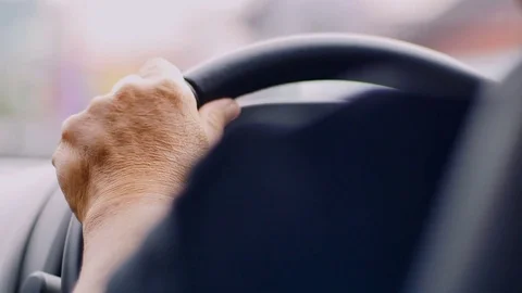 Old man driving car in day time, hand on steering wheel 库存影片 80904274