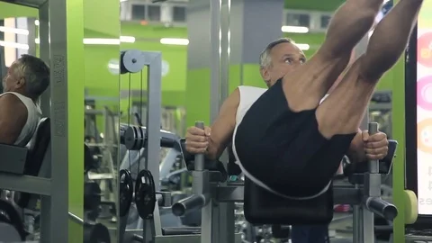 Old man is engaged on simulators in gym Stock Footage 71640549