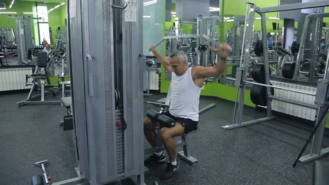 Old man is engaged on simulators in gym Video stock 71641026