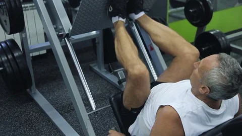 Old man is engaged on simulators in gym Stock Footage 71641362