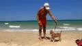 Old man with funny dog on the beach in Tunisia HD Footage