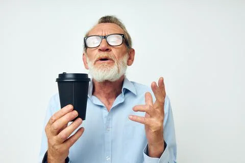 Old man gestures with his hands a glass of drink isolated background Stock Photos