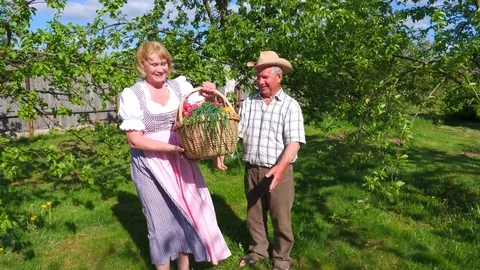 The old man gives the basket of vegetables to the woman and she thanked him. Stock Footage 76233410