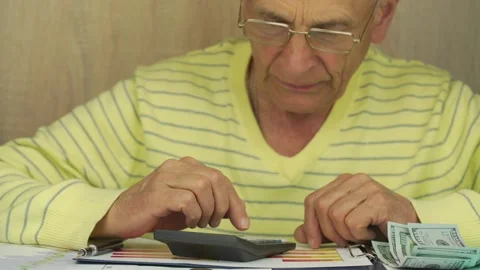 Old man in glasses and pullover counts dollar banknotes 스톡 동영상 134997778